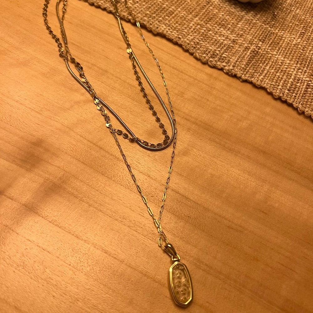 Kendra Scott multi chain with clear stone and mini daisy flower pendant.